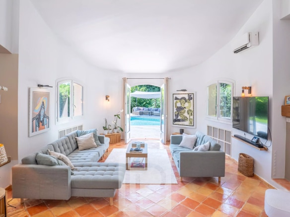 Intérieur d'une villa provençale rénovée avec salon lumineux et accès à la piscine.