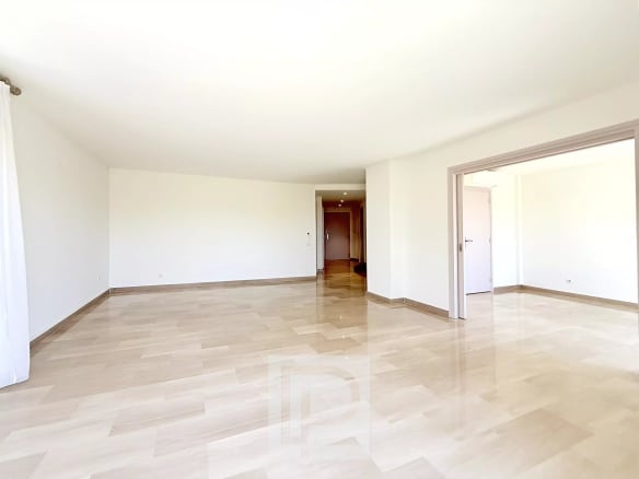 Interior of a spacious apartment with marble flooring and light-colored walls, without furniture.