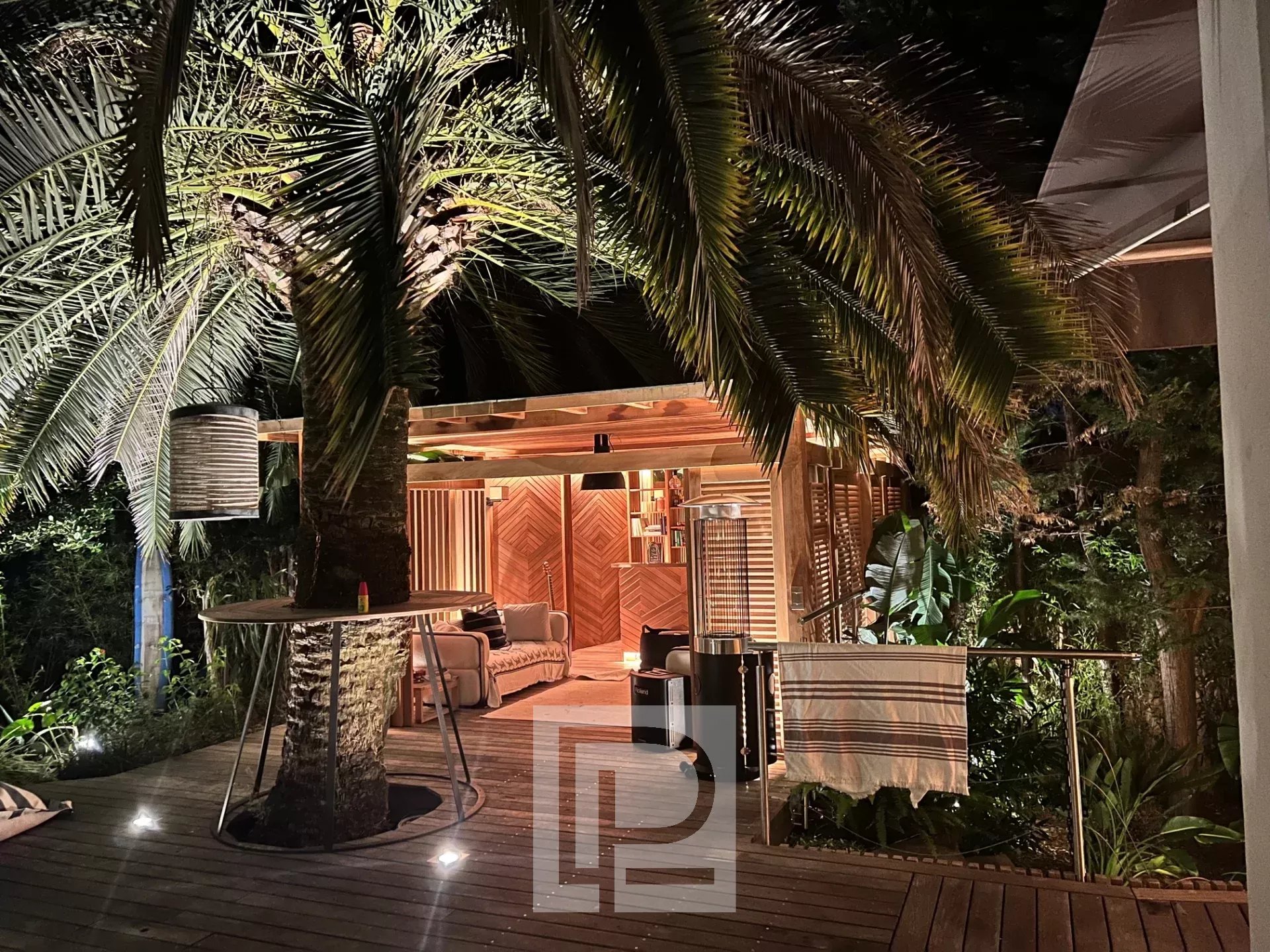 Terrace of an artist's house in Cannes, with palm trees and an outdoor living space.