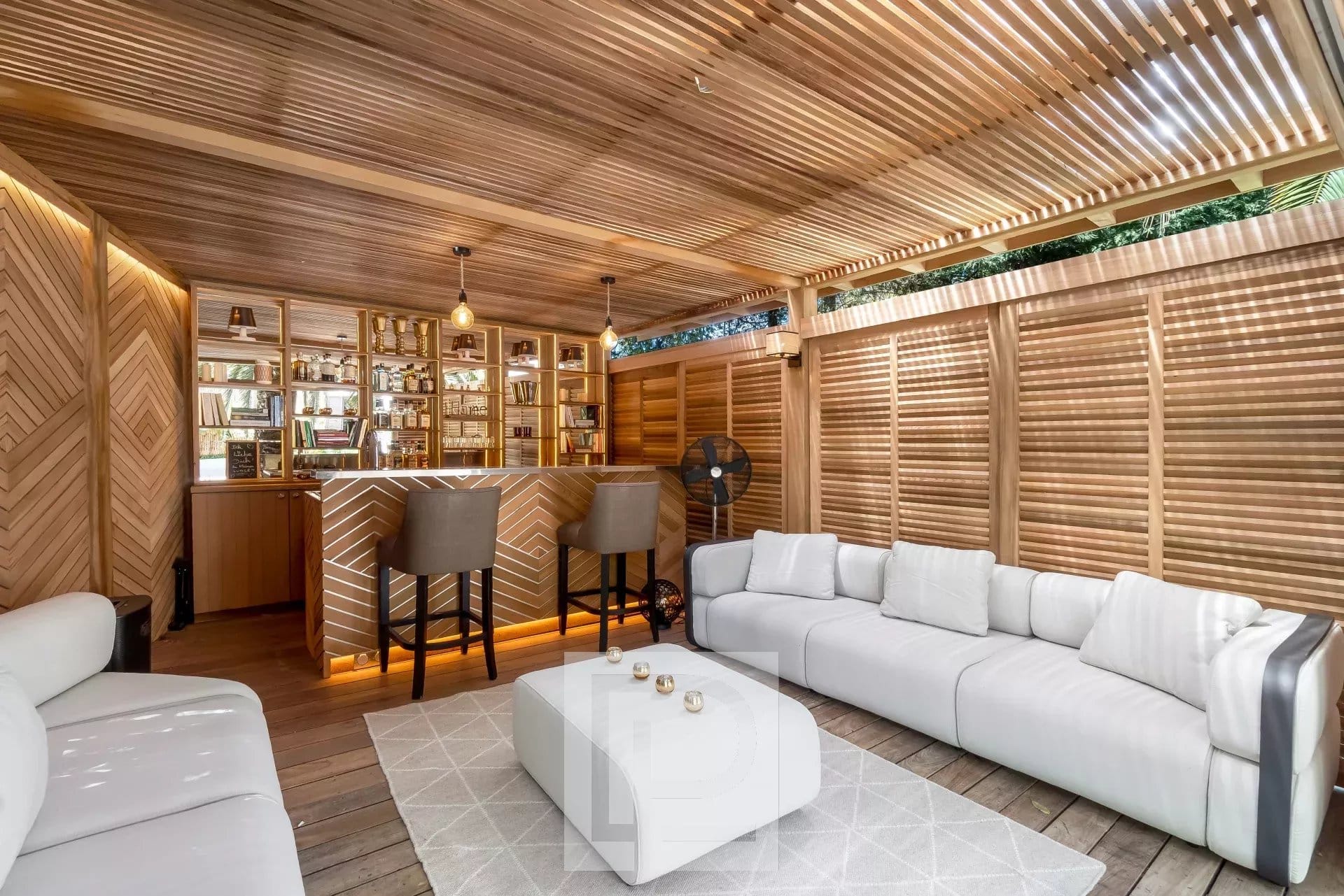 Modern living room with bar, white sofas and warm lighting in an artist's house in Cannes.