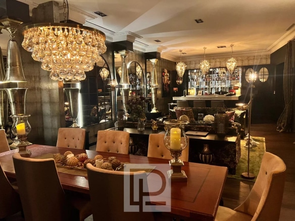 Interior of an artist's house in Cannes with chic baroque decor, dining table and bar.