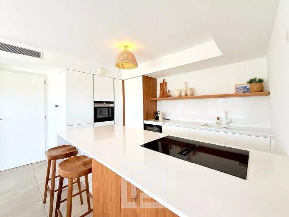 Cuisine moderne avec îlot central et bar, éclairage naturel, dans un appartement à Mougins.