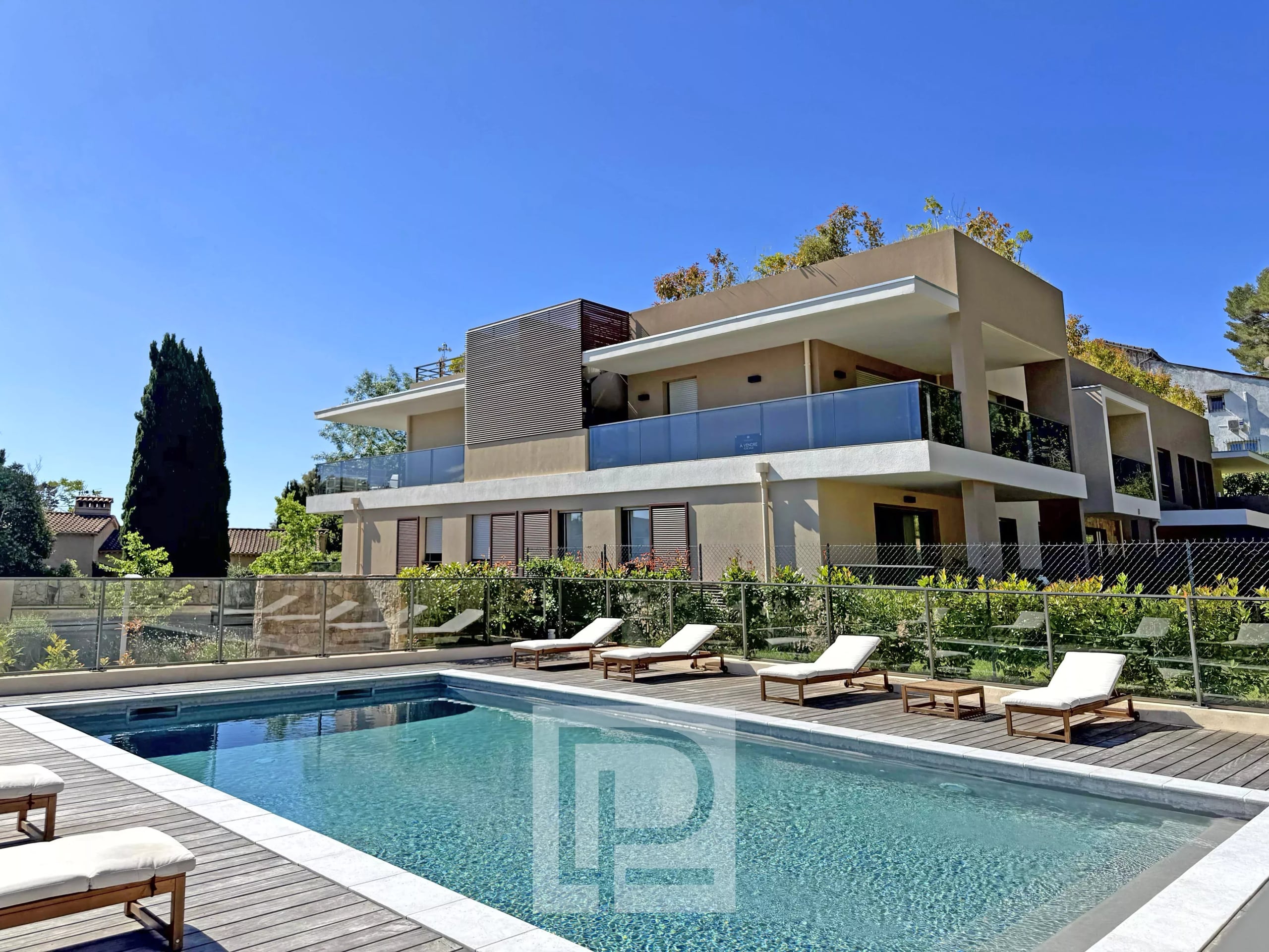 Vue d'un appartement avec piscine dans un domaine fermé à Mougins, ensoleillé et verdoyant.
