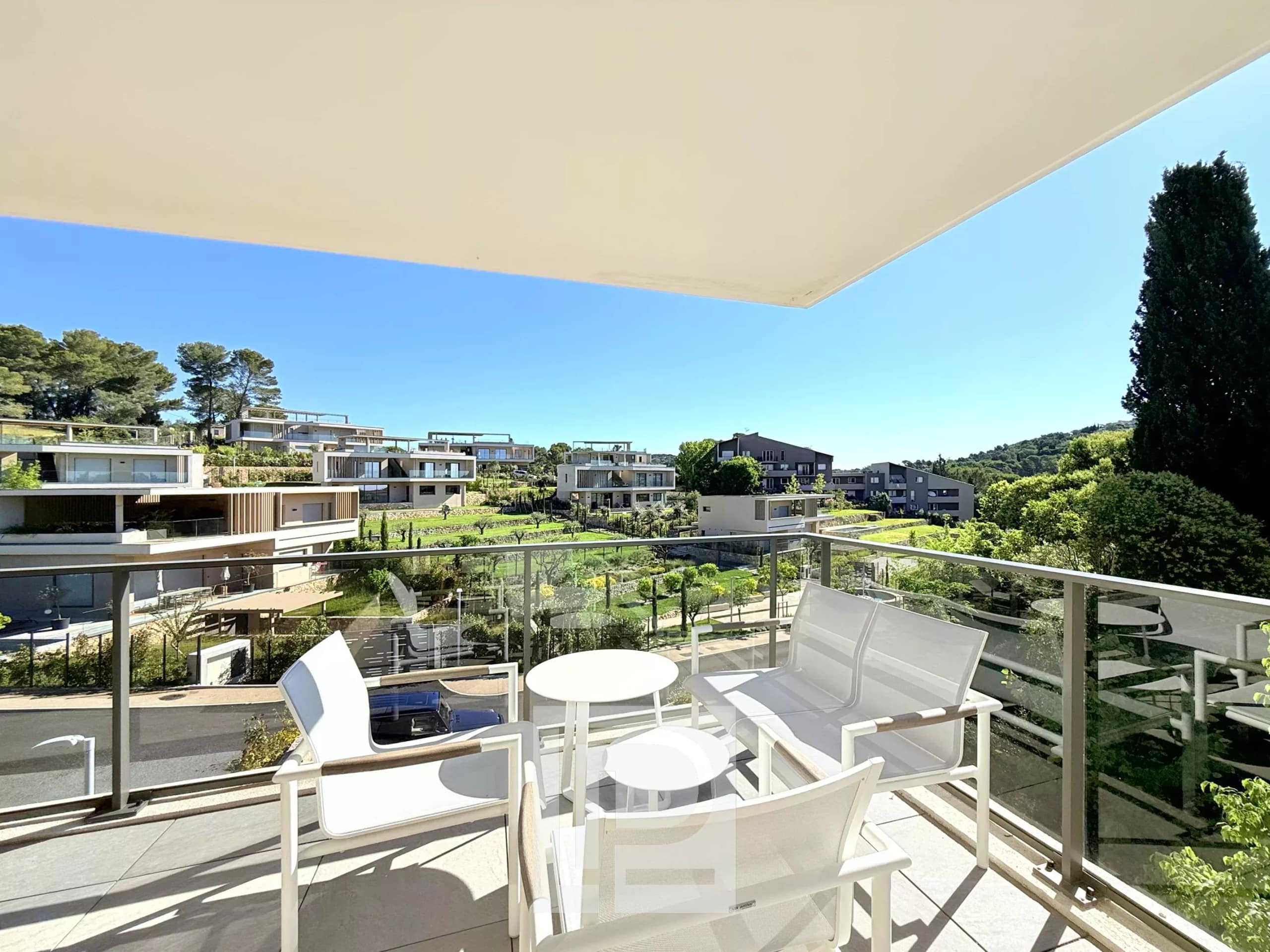 Terrasse d'un appartement avec mobilier moderne et vue sur un domaine résidentiel à Mougins.