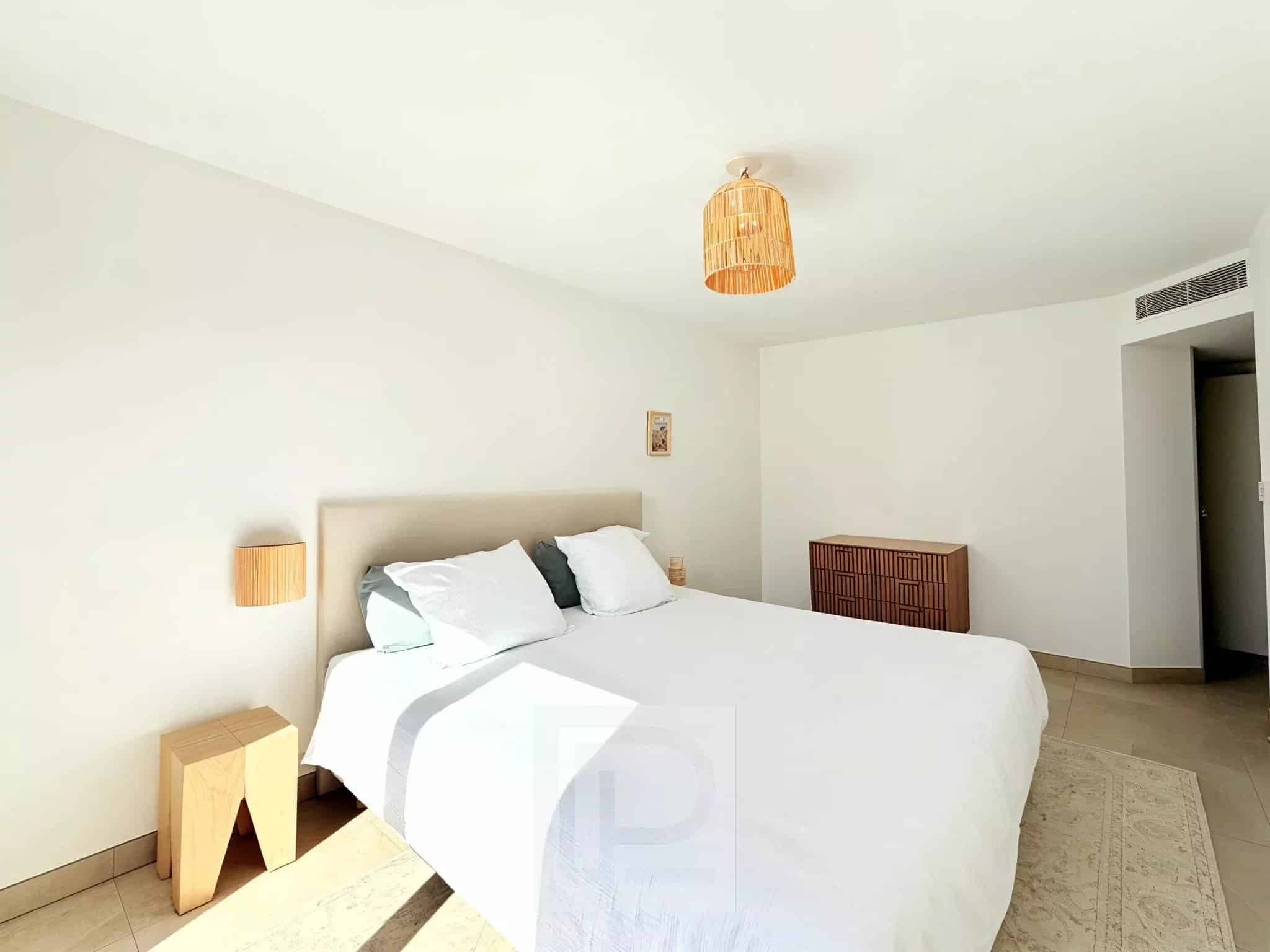 Chambre d'un appartement moderne avec lit double et décoration minimaliste.
