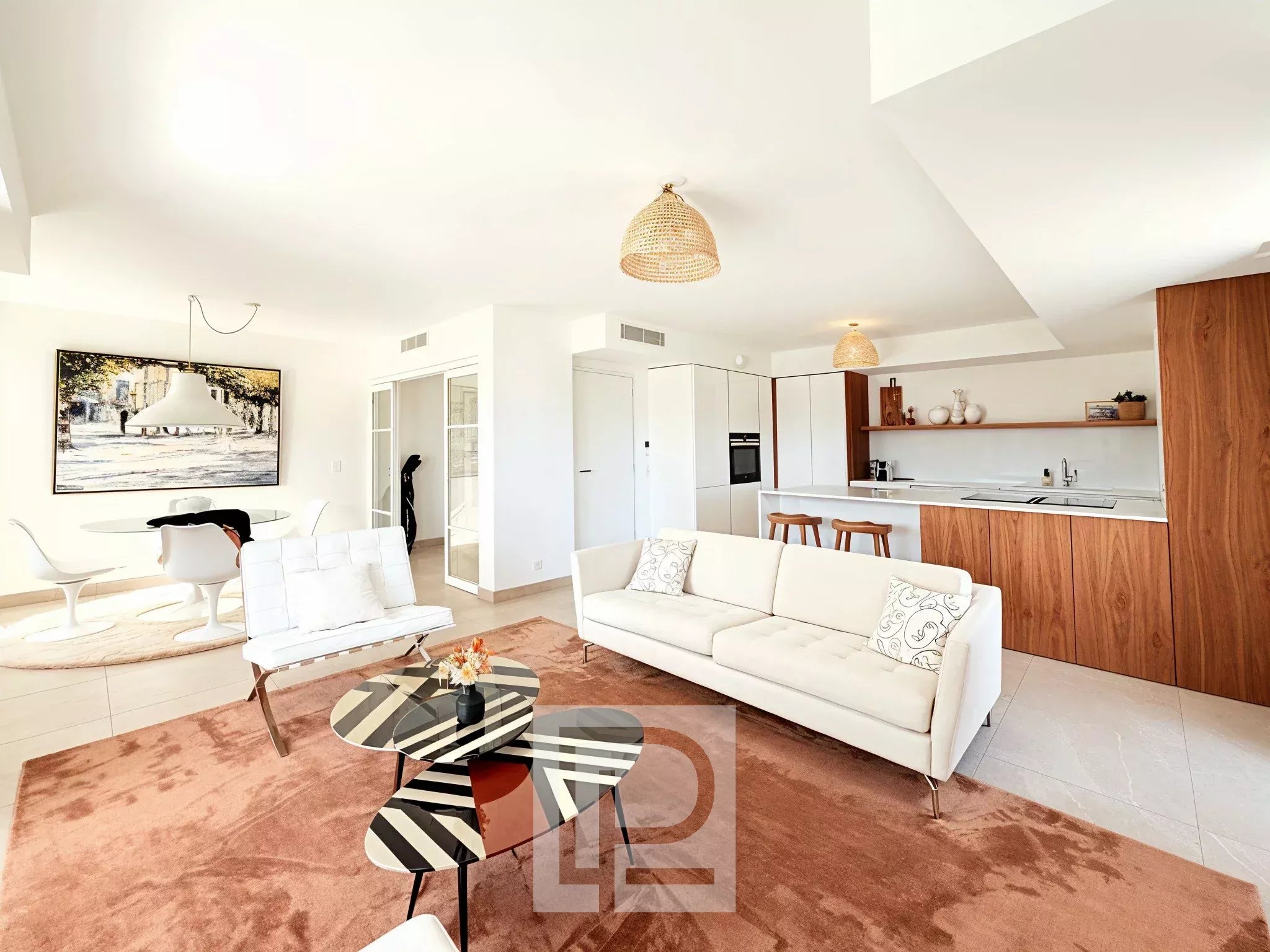Intérieur d'un appartement moderne avec salon lumineux, cuisine ouverte et décoration contemporaine.