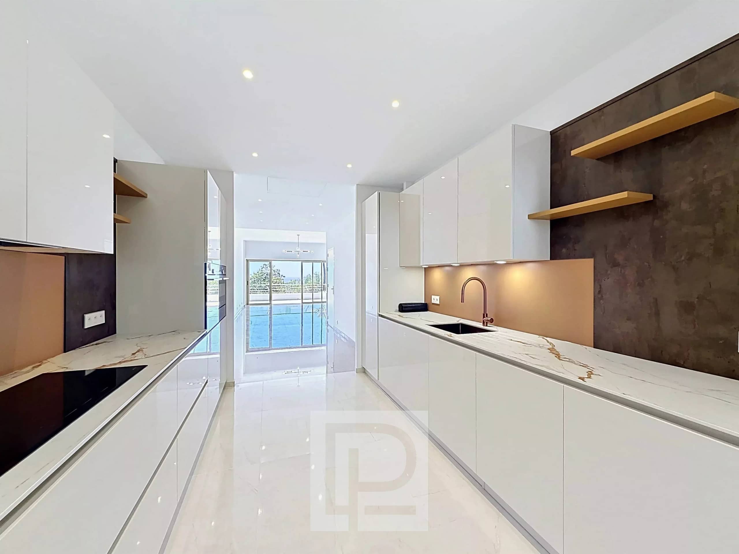 Modern and bright kitchen in an apartment in Cannes, with marble worktops and large windows.