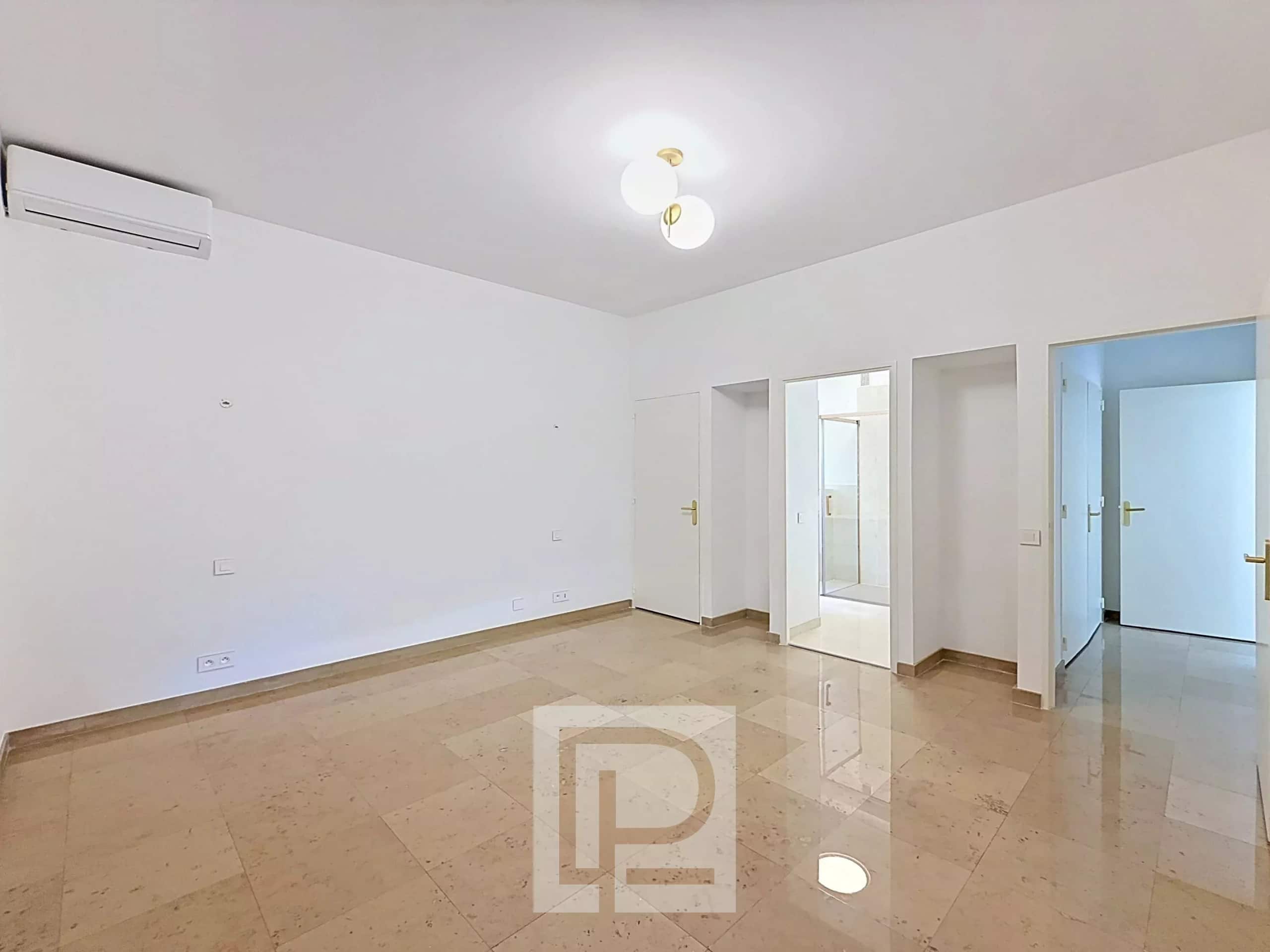 Interior of an empty apartment with marble floor and white walls, natural light, Isola Bella area in Cannes.