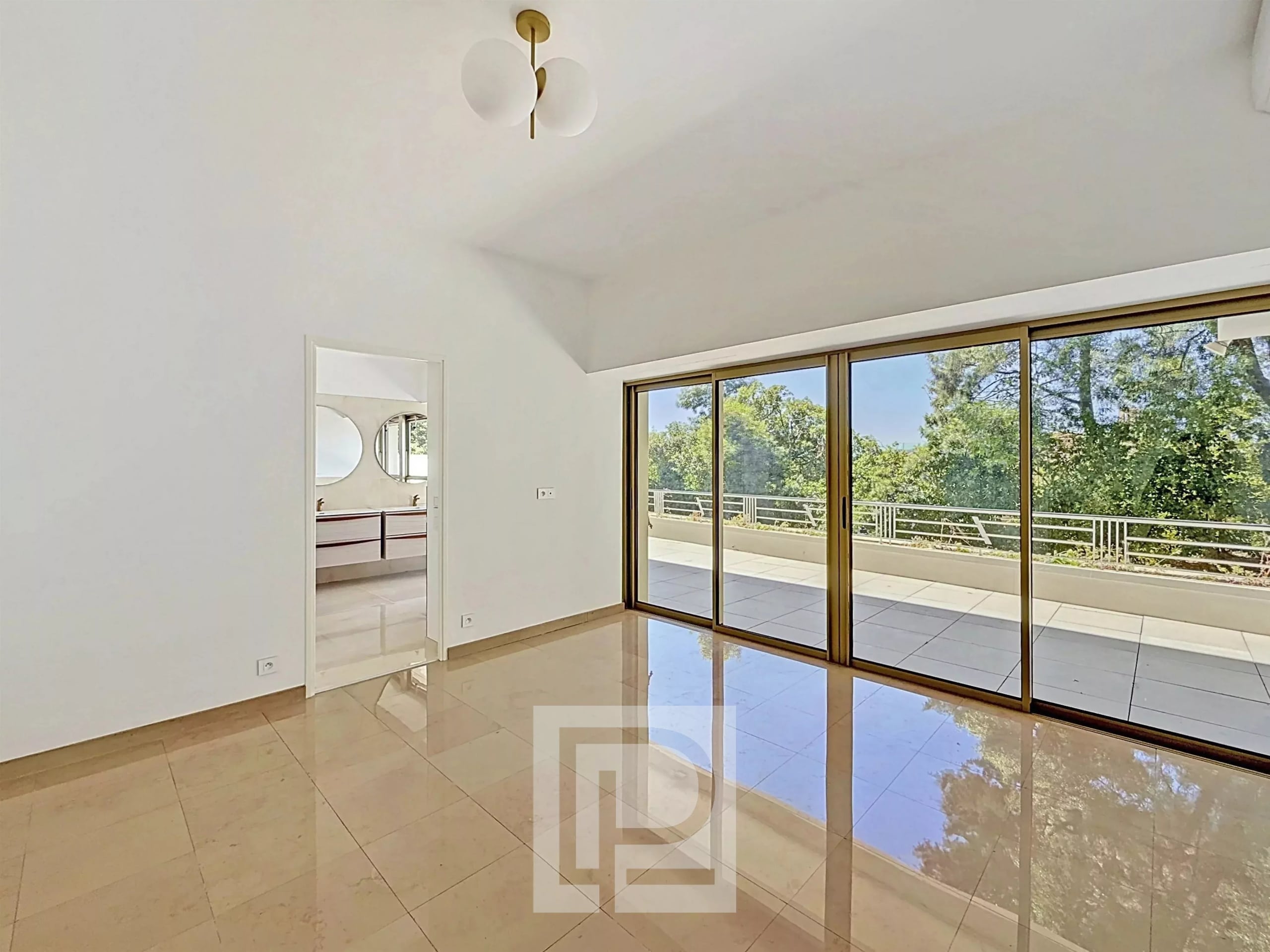 Interior of a bright apartment with large bay windows and access to a terrace.