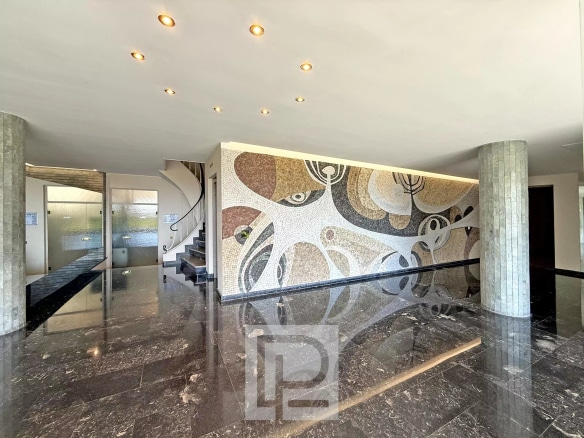 Entrance hall of a luxury residence with a marble floor and mosaic wall decoration.