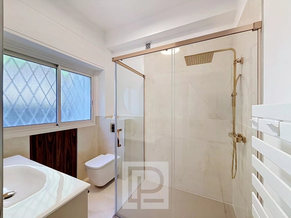 Modern bathroom with walk-in shower and sink in an apartment in Cannes.