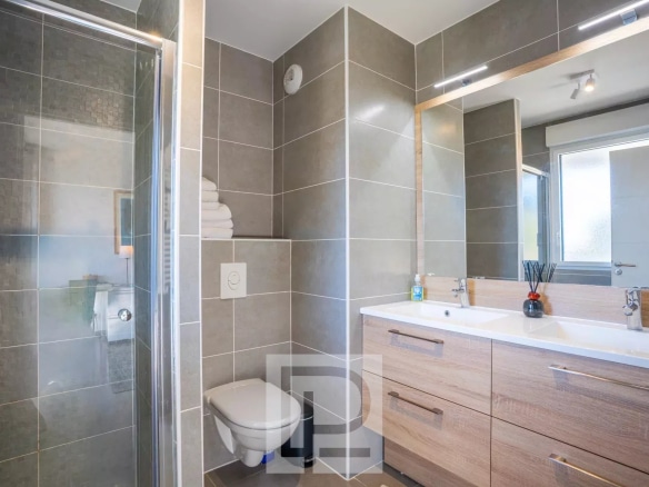 Salle de bain moderne avec douche, lavabo et toilettes dans un appartement au Cannet.