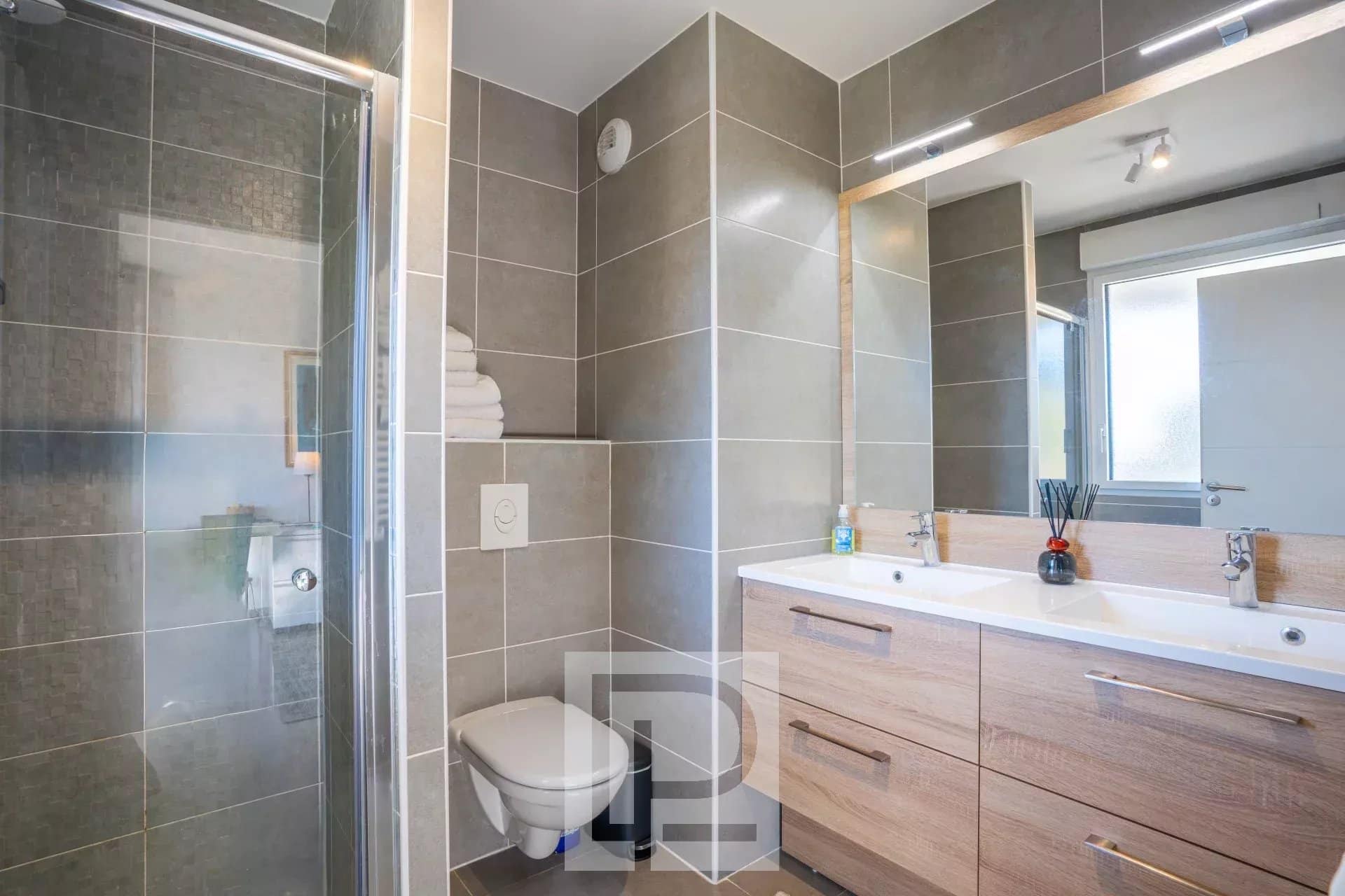 Salle de bain moderne avec douche, lavabo et toilettes dans un appartement au Cannet.