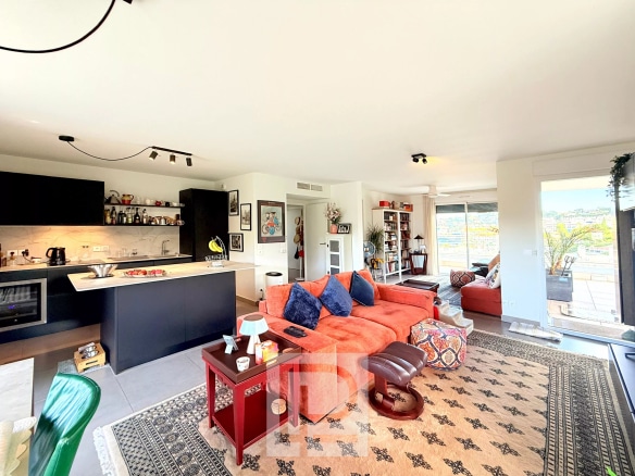 Salon lumineux d'un appartement moderne avec vue sur les collines et la mer, décoration contemporaine.