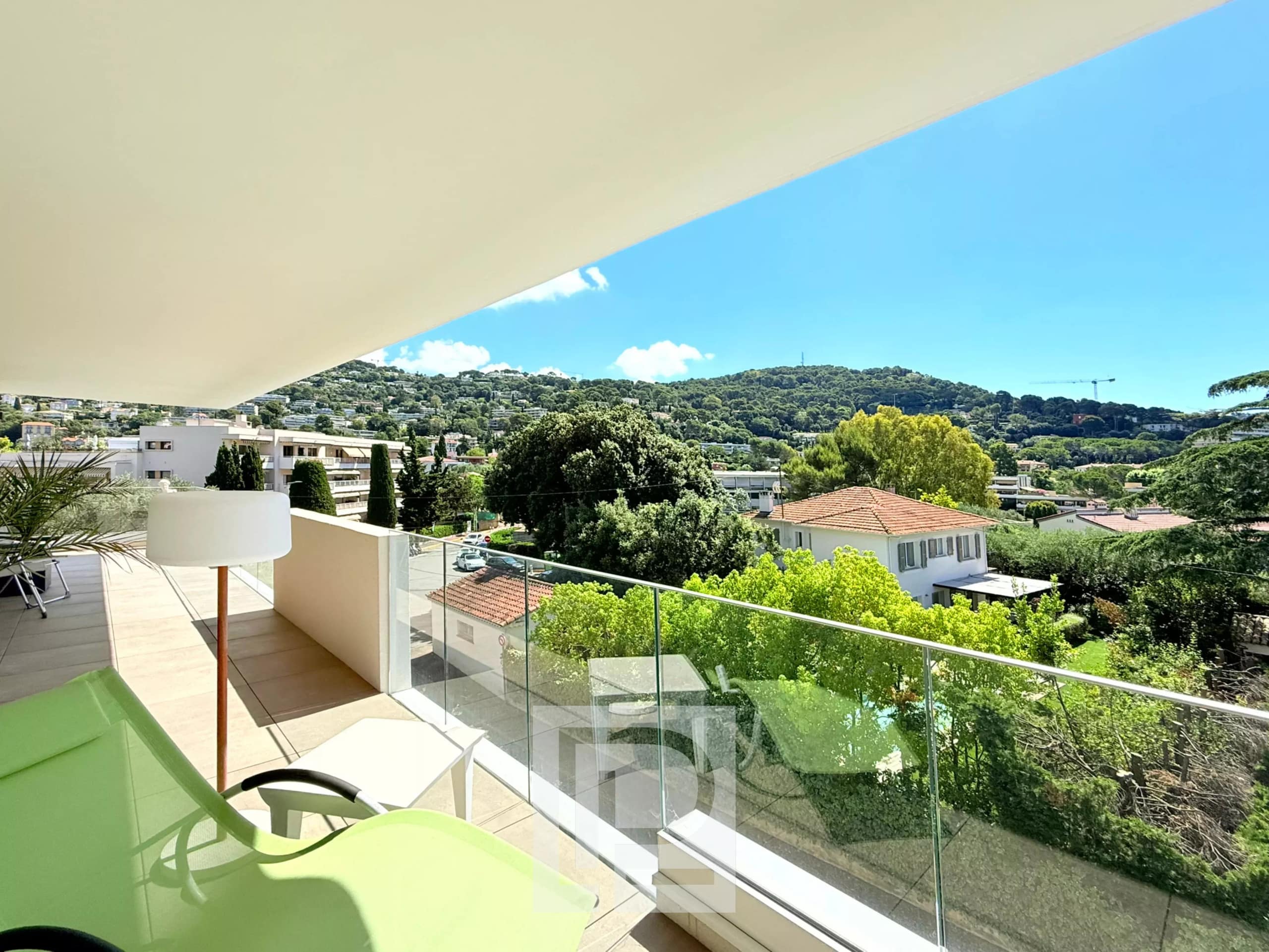 Vue dégagée sur les collines et la mer depuis un balcon d'appartement au Cannet.