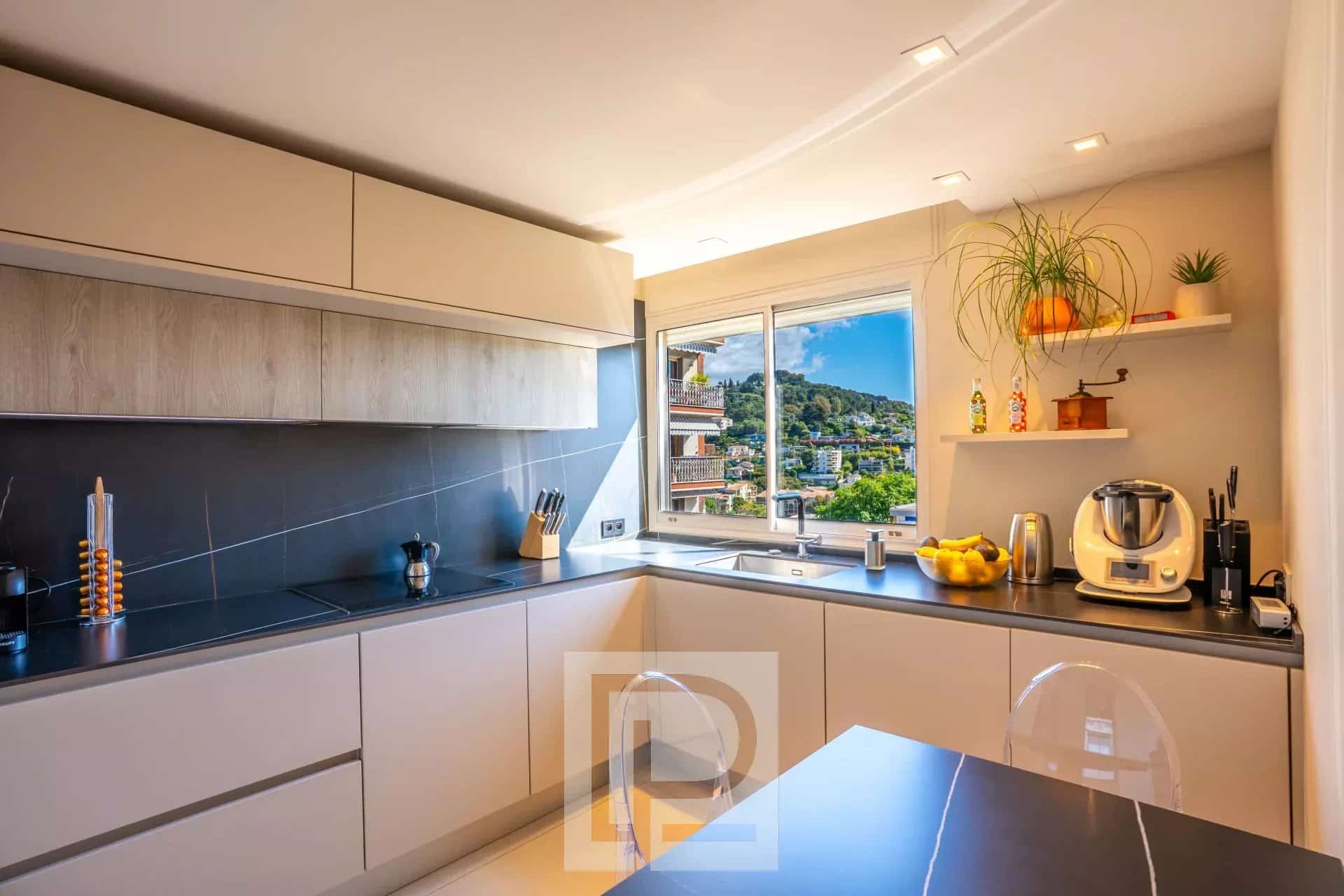 Cuisine d’un appartement au Cannet Cuisine moderne et lumineuse d'un appartement rénové avec vue sur le paysage.