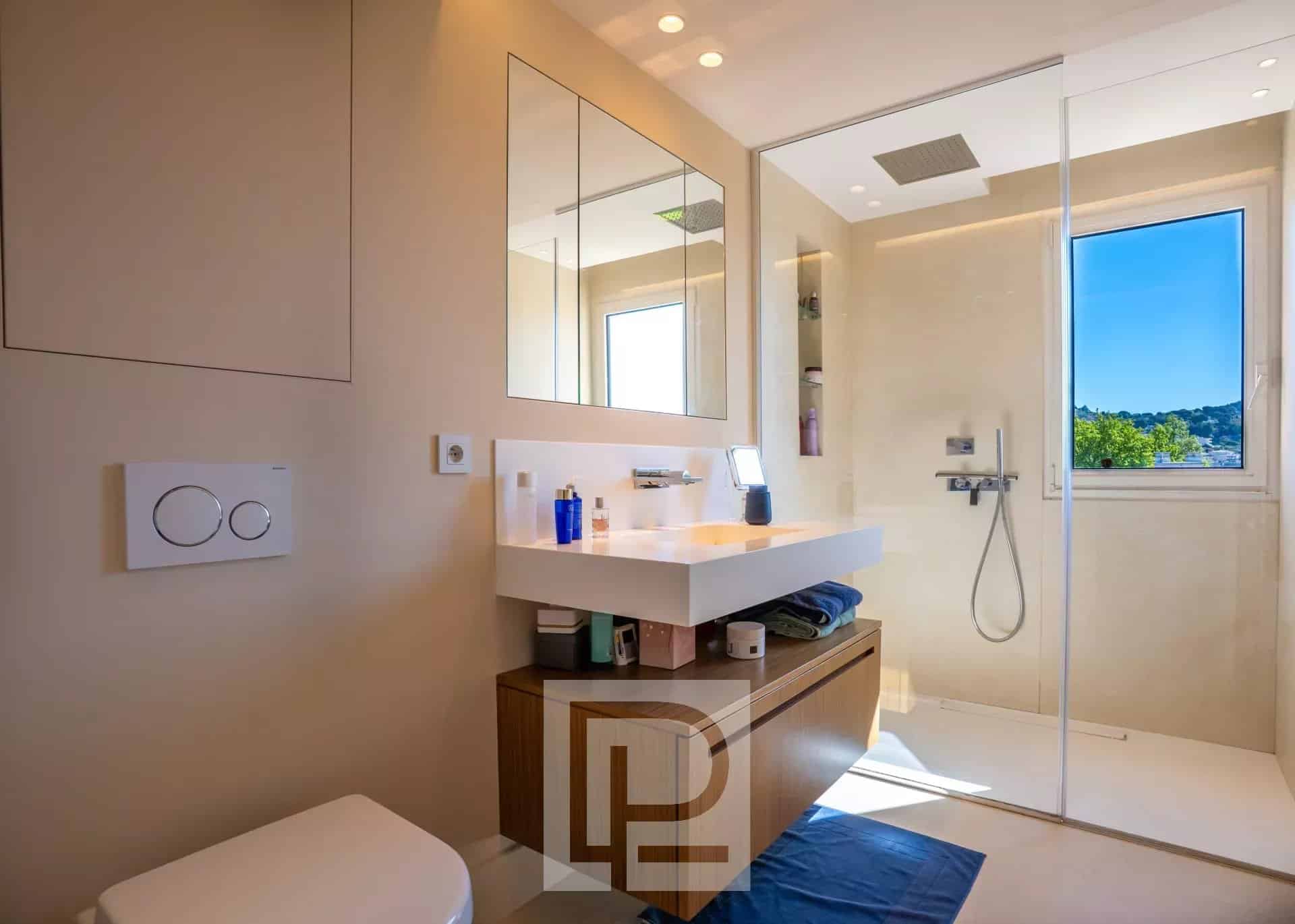 Salle de bain d’un appartement rénové Salle de bain moderne avec douche et meuble sous vasque dans un appartement rénové.