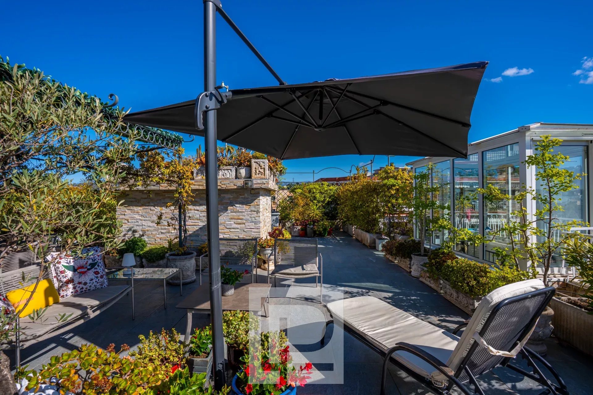 Terrasse d’appartement au Montjoli Terrasse panoramique d'un appartement au dernier étage avec mobilier et parasol, vue dégagée.