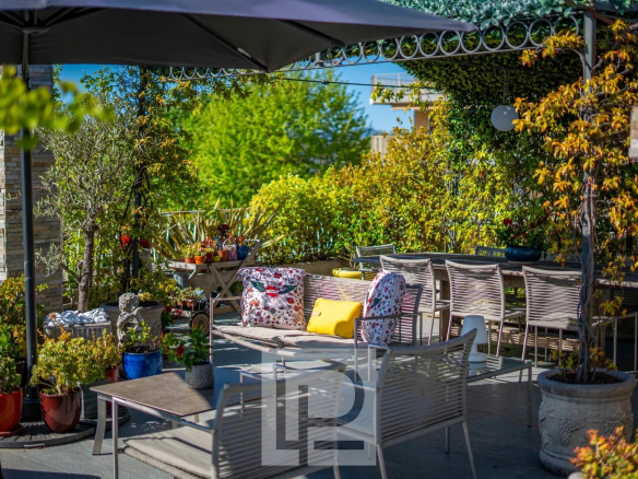 Terrasse panoramique d'un appartement rénové avec mobilier de jardin et verdure au Cannet.