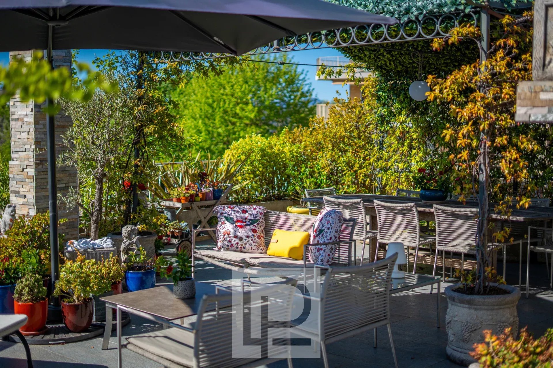 Terrasse d’appartement luxueux au Cannet Terrasse panoramique d'un appartement rénové avec mobilier de jardin et verdure au Cannet.