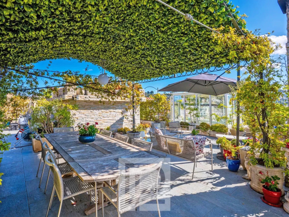 Terrasse panoramique d'un appartement rénové avec mobilier extérieur et verdure, Le Cannet.