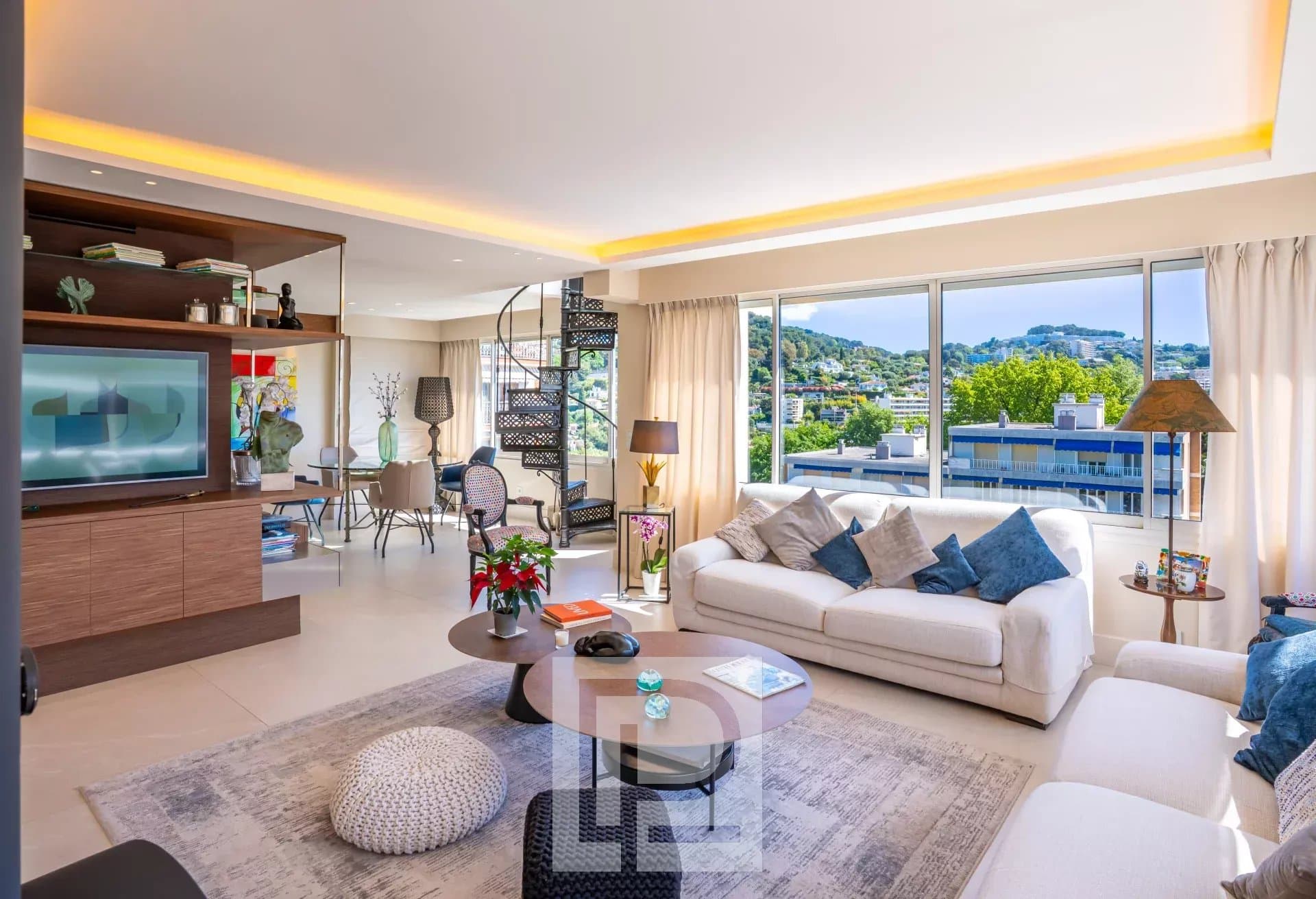 Salon d’un appartement au Montjoli Salon lumineux d'un appartement rénové avec vue sur la ville et la mer, mobilier moderne.