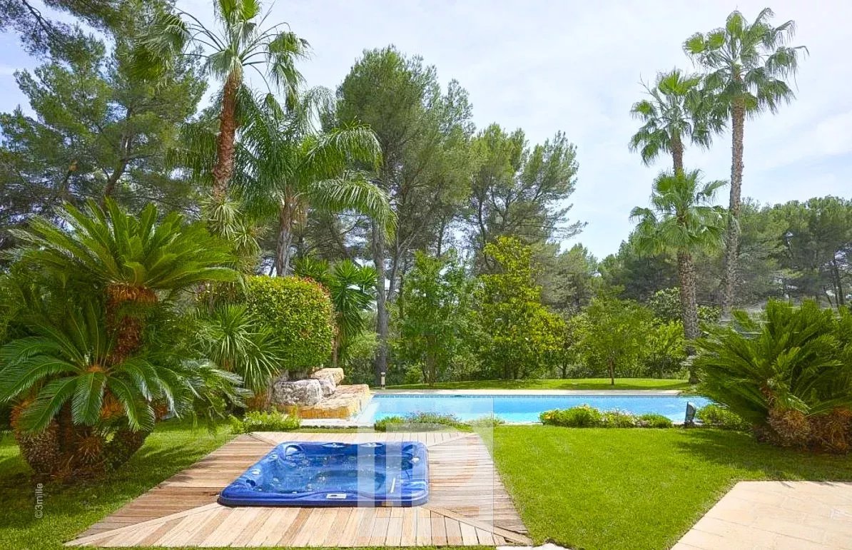 Jardin avec piscine à Mougins Jardin avec piscine et jacuzzi entouré de palmiers à Mougins.