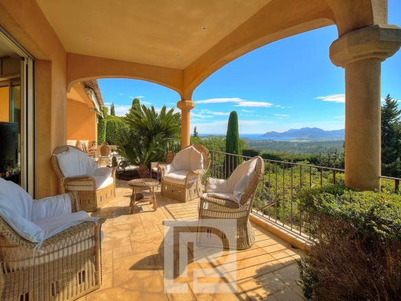 Terrasse d'une villa à Mougins avec vue panoramique sur la mer et l'arrière-pays, meubles en osier.