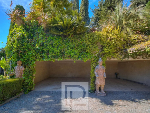 Entrée d'une propriété avec des statues et de la végétation luxuriante à Mougins.