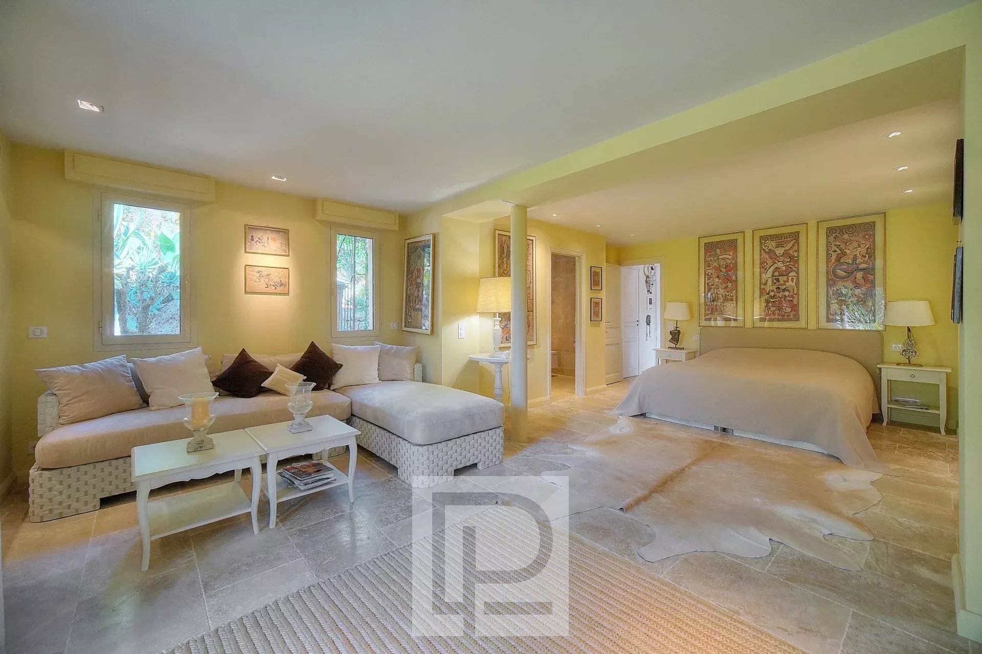 Intérieur d'une villa à Mougins avec salon et chambre, décor chaleureux et lumineux.