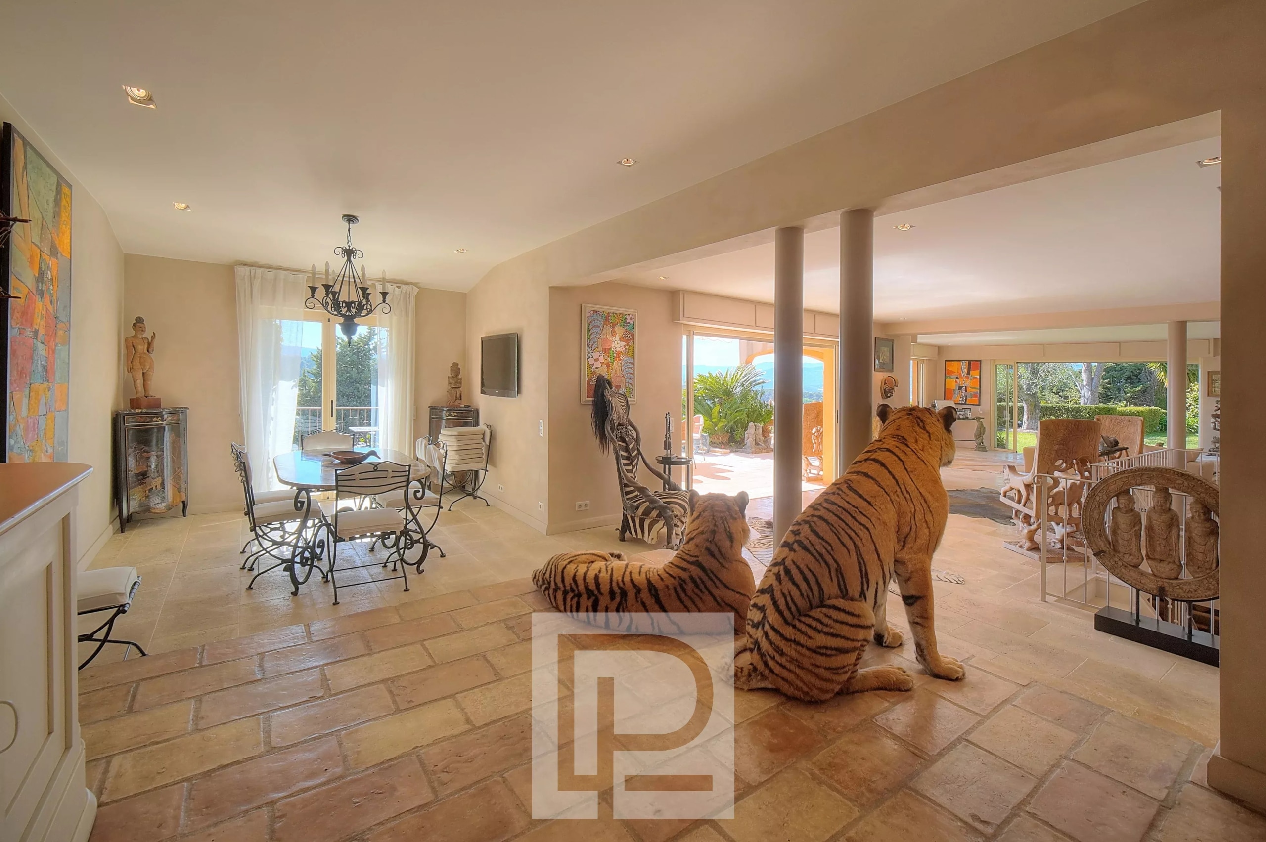 Intérieur d'une villa à Mougins avec des sculptures de tigres et une vue sur la mer.