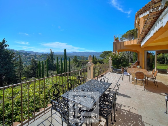 Terrasse d'une villa à Mougins avec vue sur la mer et l'arrière-pays, mobilier extérieur présent.