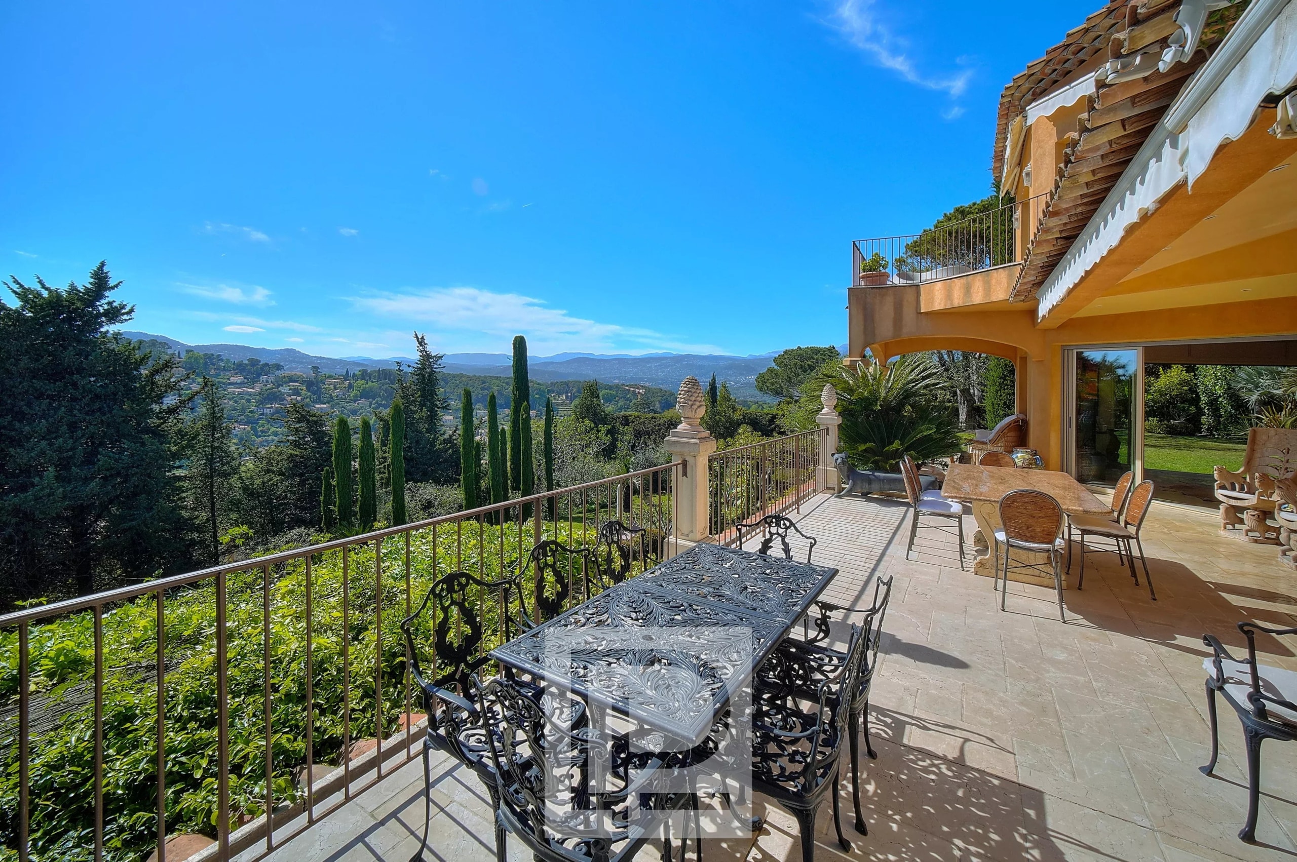 Terrasse d'une villa à Mougins avec vue sur la mer et l'arrière-pays, mobilier extérieur présent.