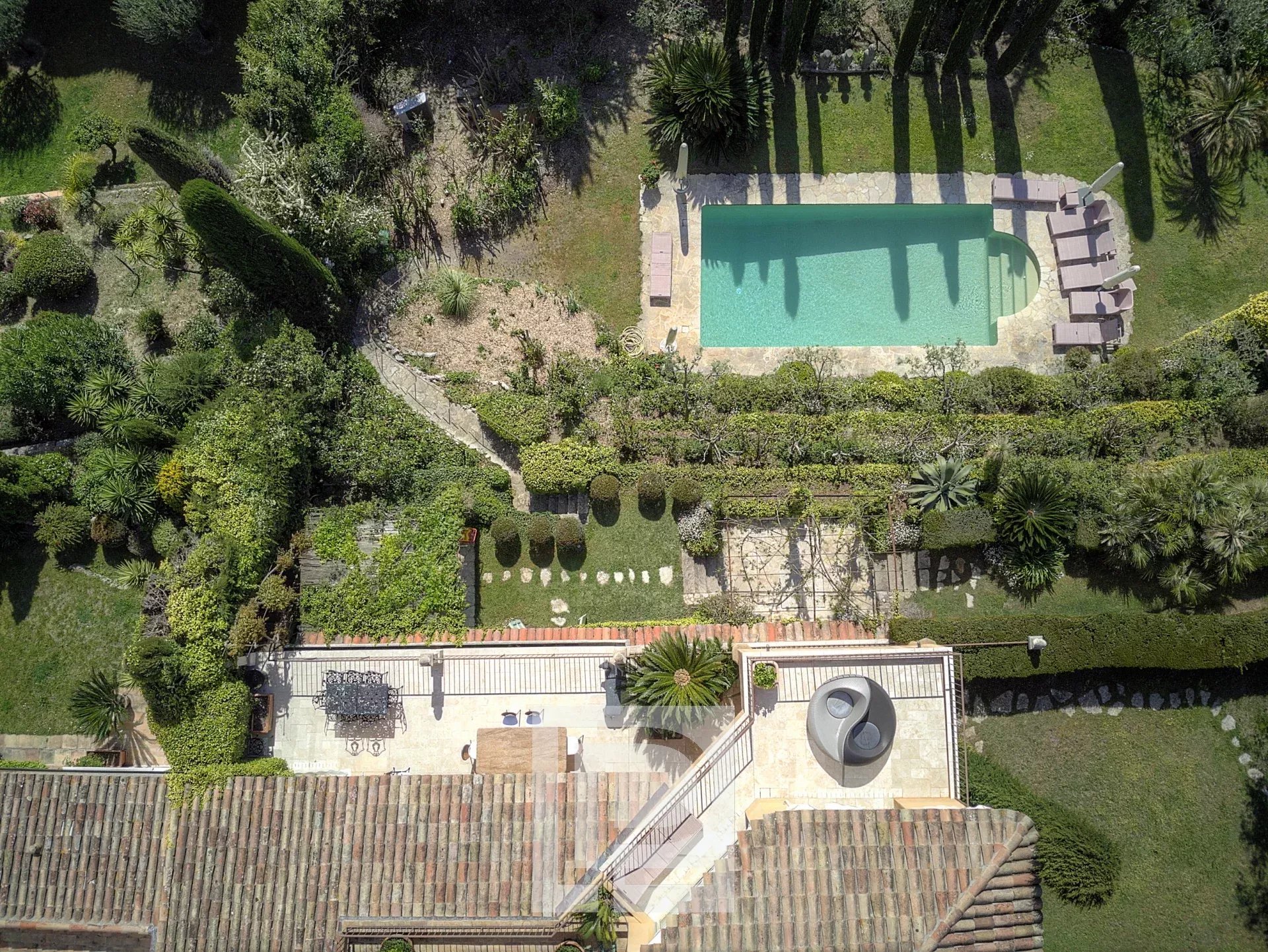 Vue aérienne d'une propriété avec piscine et jardin à Mougins, entourée de verdure.