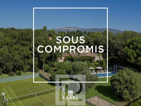 Vue aérienne d'une villa avec terrain de tennis et piscine, entourée de verdure à Mougins.