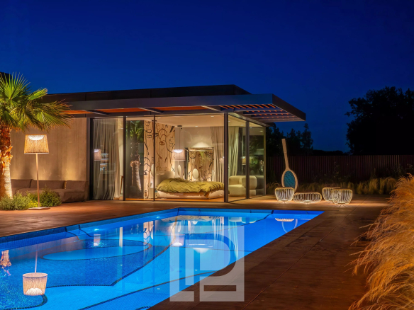 Contemporary villa with swimming pool and outdoor living space in Mougins, illuminated at night.