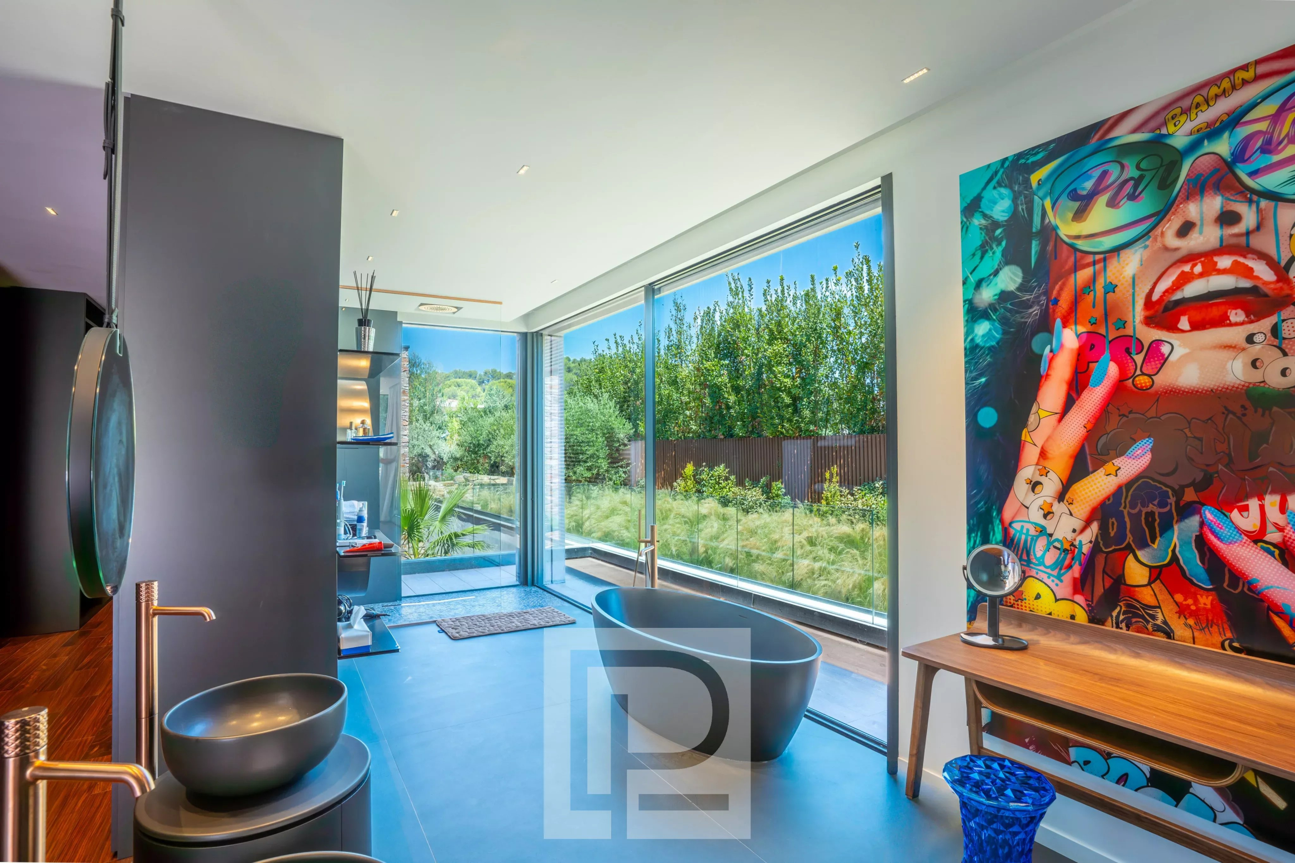 Contemporary bathroom in Mougins Modern bathroom with bathtub, garden view, artistic decoration in Mougins.