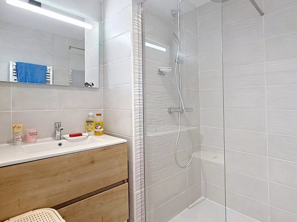 Salle de bain moderne avec douche à l'italienne et meuble en bois.