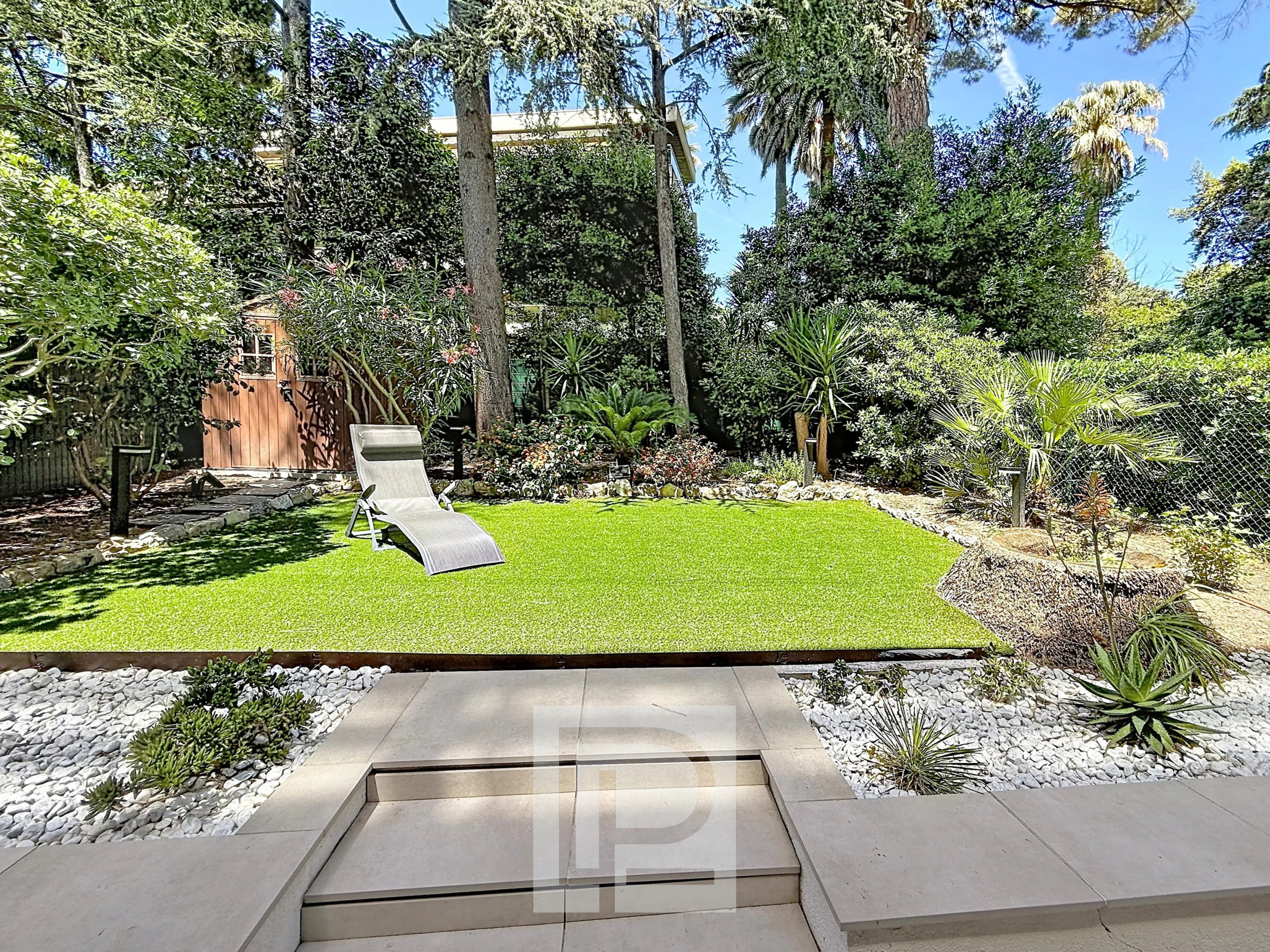 Private garden in Cannes Private garden of a renovated apartment in Cannes with lawn and landscaping.