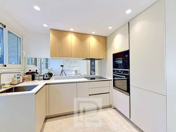Modern and bright kitchen in a renovated apartment in Cannes, with high-end equipment.