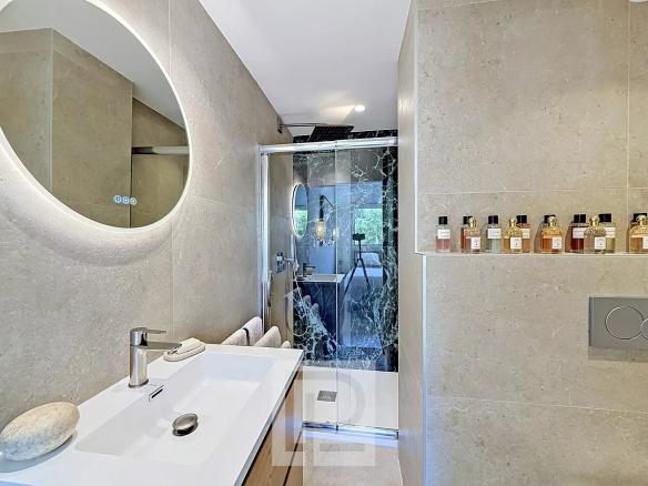 Modern bathroom with glass shower and sink, decorated with light and refined materials.