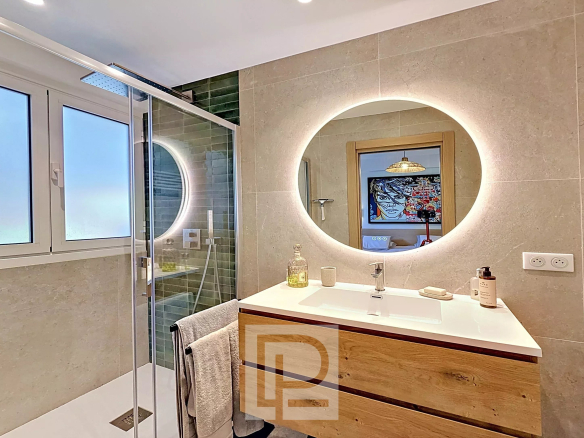Modern bathroom with walk-in shower and wooden vanity, natural light