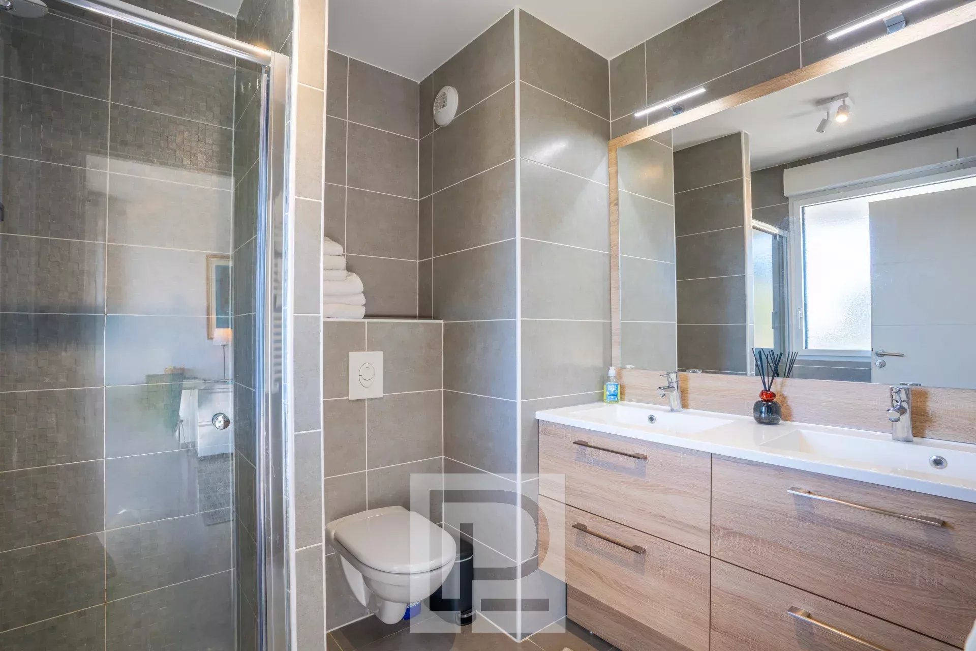 Salle de bains moderne avec douche, lavabo et toilettes dans un appartement récent au Cannet.