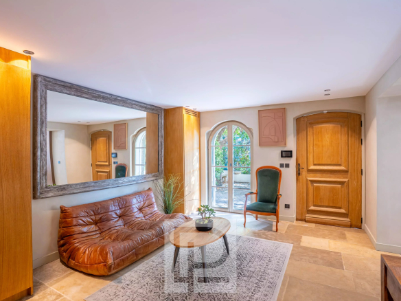 Intérieur d'une bastide rénovée avec un canapé en cuir et des murs en pierre naturelle.