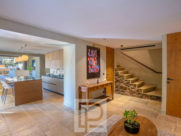 Intérieur d'une bastide rénovée avec cuisine moderne et escaliers en pierre.