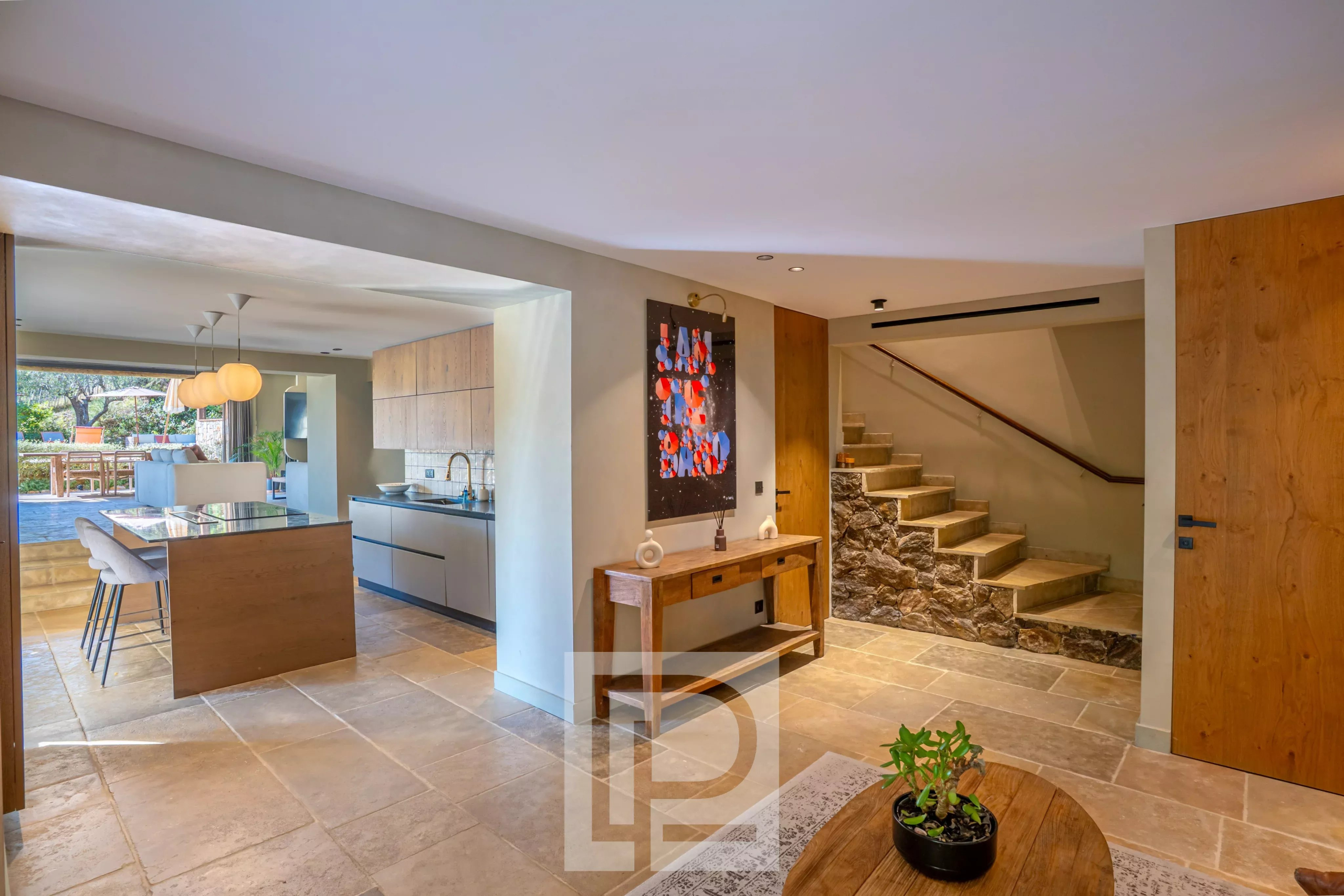 Intérieur d’une bastide à Pégomas Intérieur d'une bastide rénovée avec cuisine moderne et escaliers en pierre.