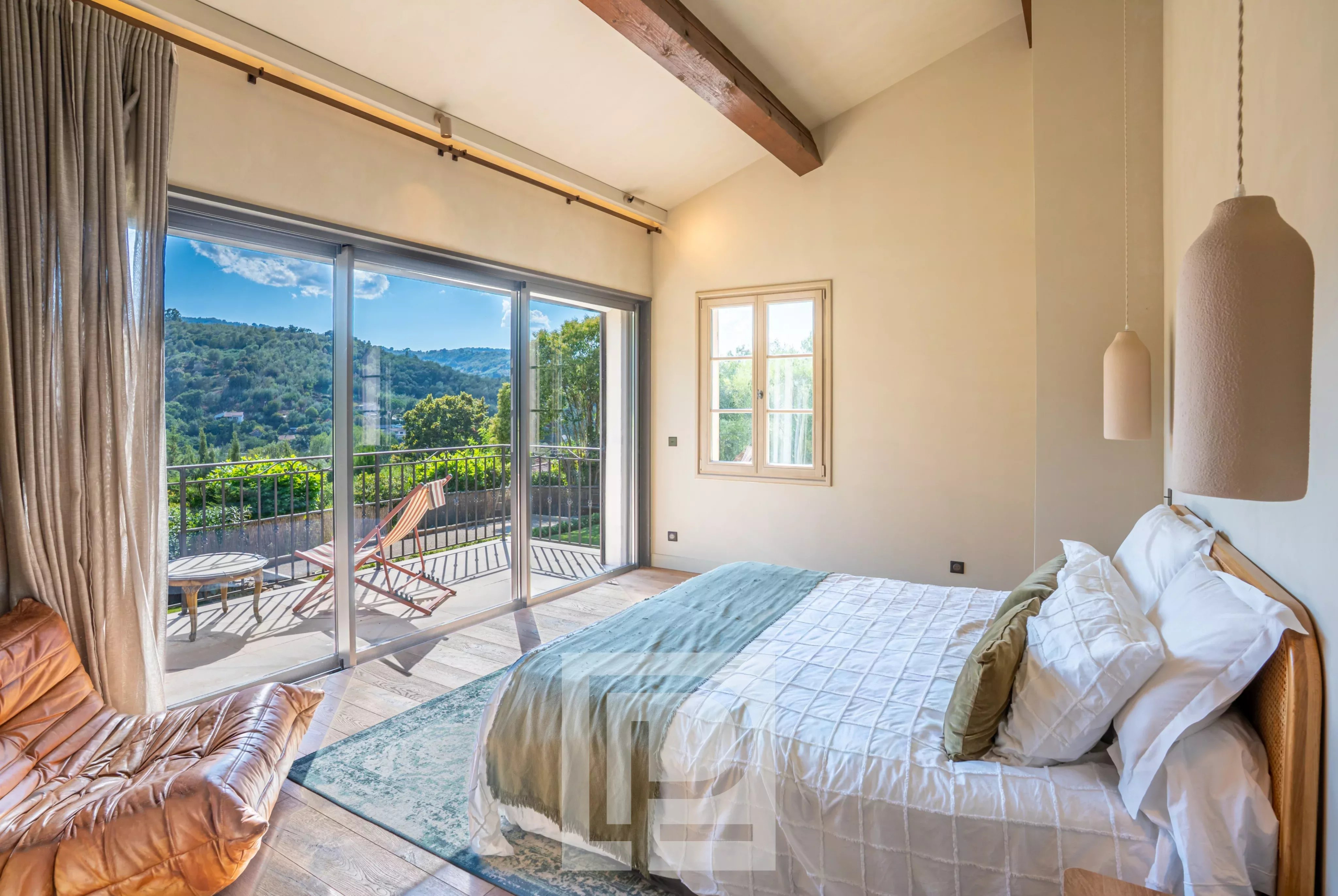Chambre avec vue dégagée Chambre lumineuse avec vue sur les collines, fenêtres ouvertes sur un balcon.