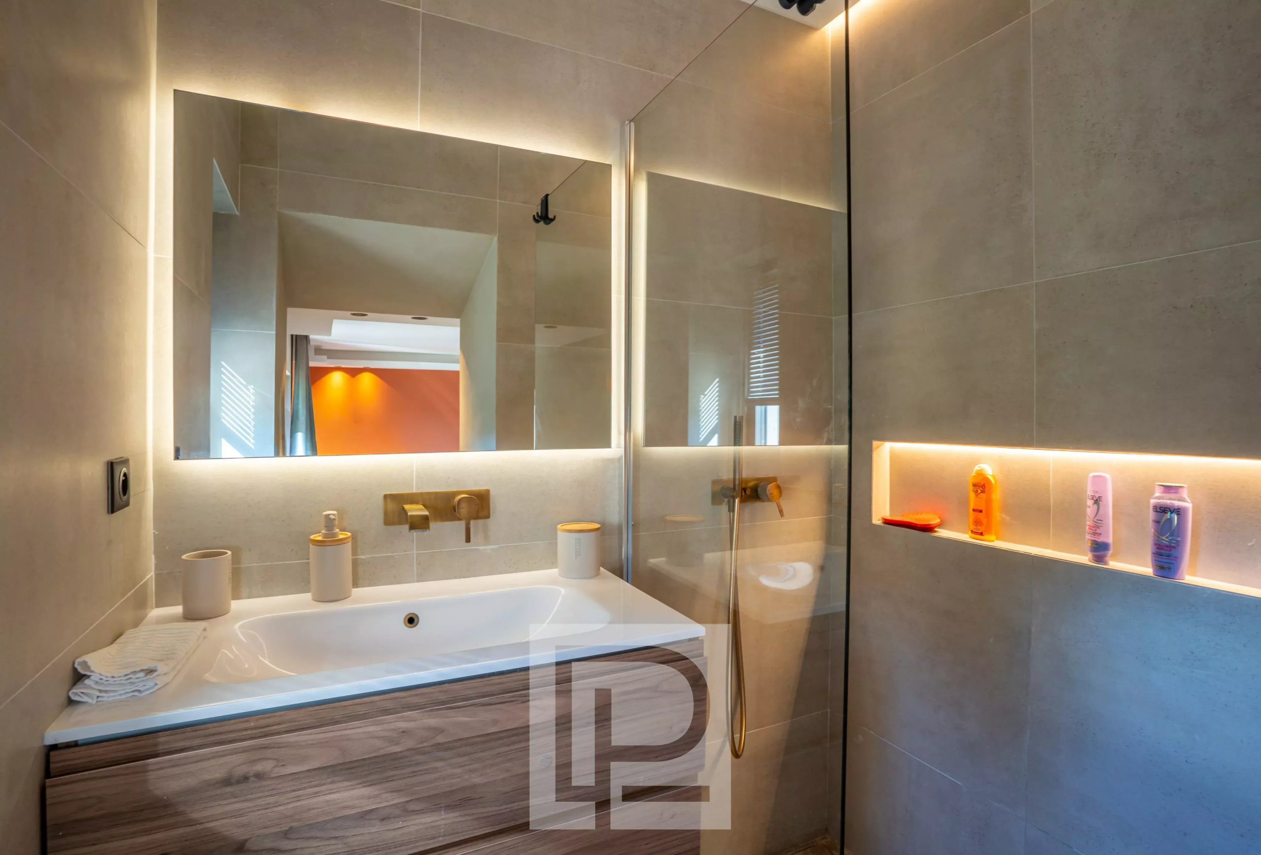 Salle de bain d’une bastide rénovée Salle de bain moderne avec baignoire, miroir et éclairage, dans une bastide rénovée.