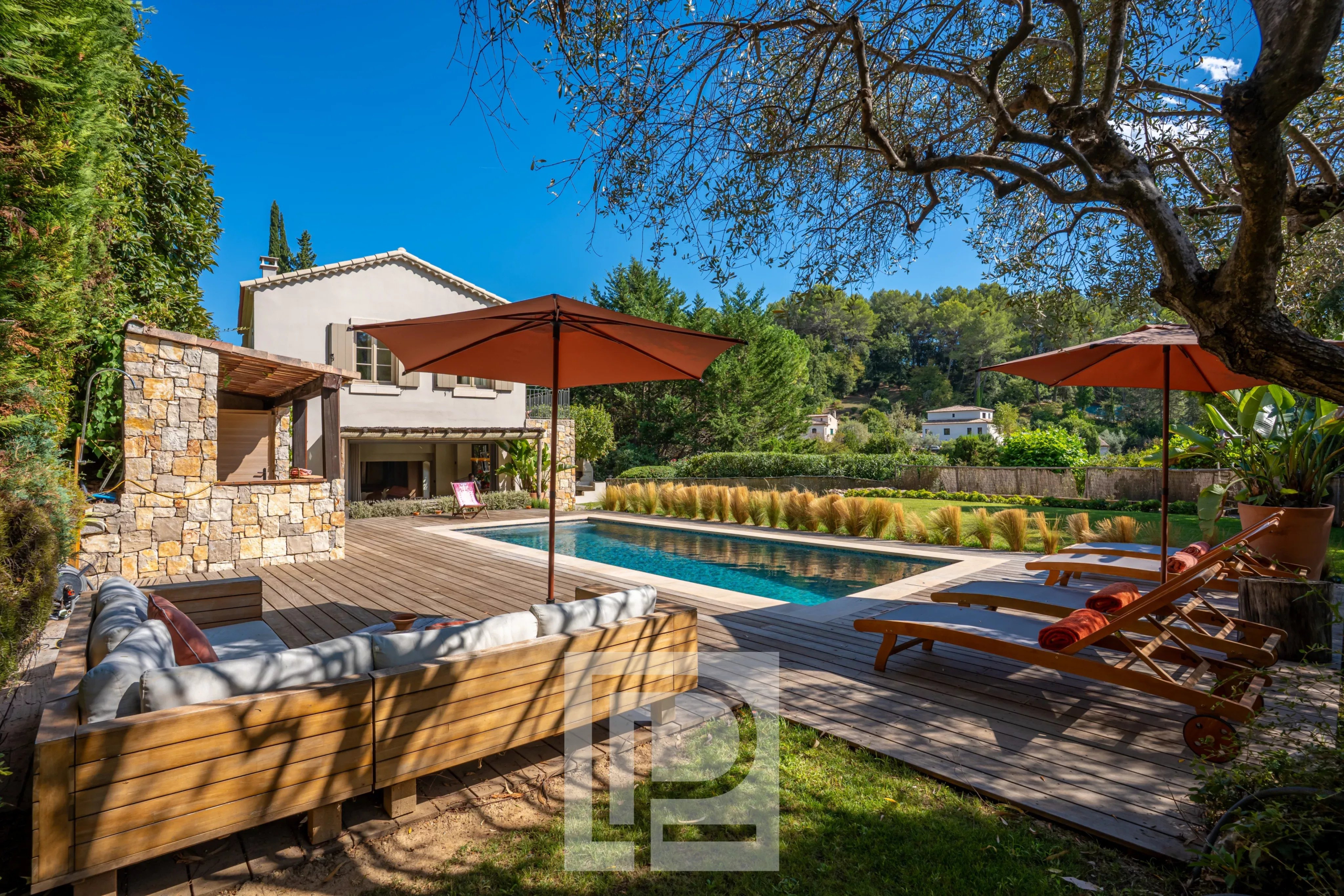 Bastide rénovée à Pégomas Bastide rénovée avec piscine et terrasse en bois à Pégomas, entourée de verdure.