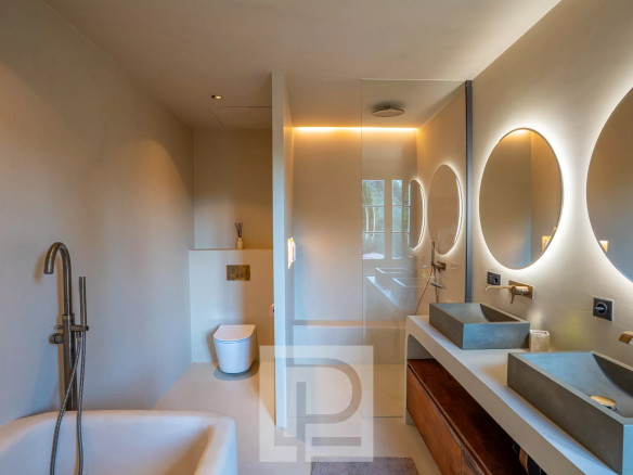 Salle de bain moderne avec baignoire, douche et double vasque.